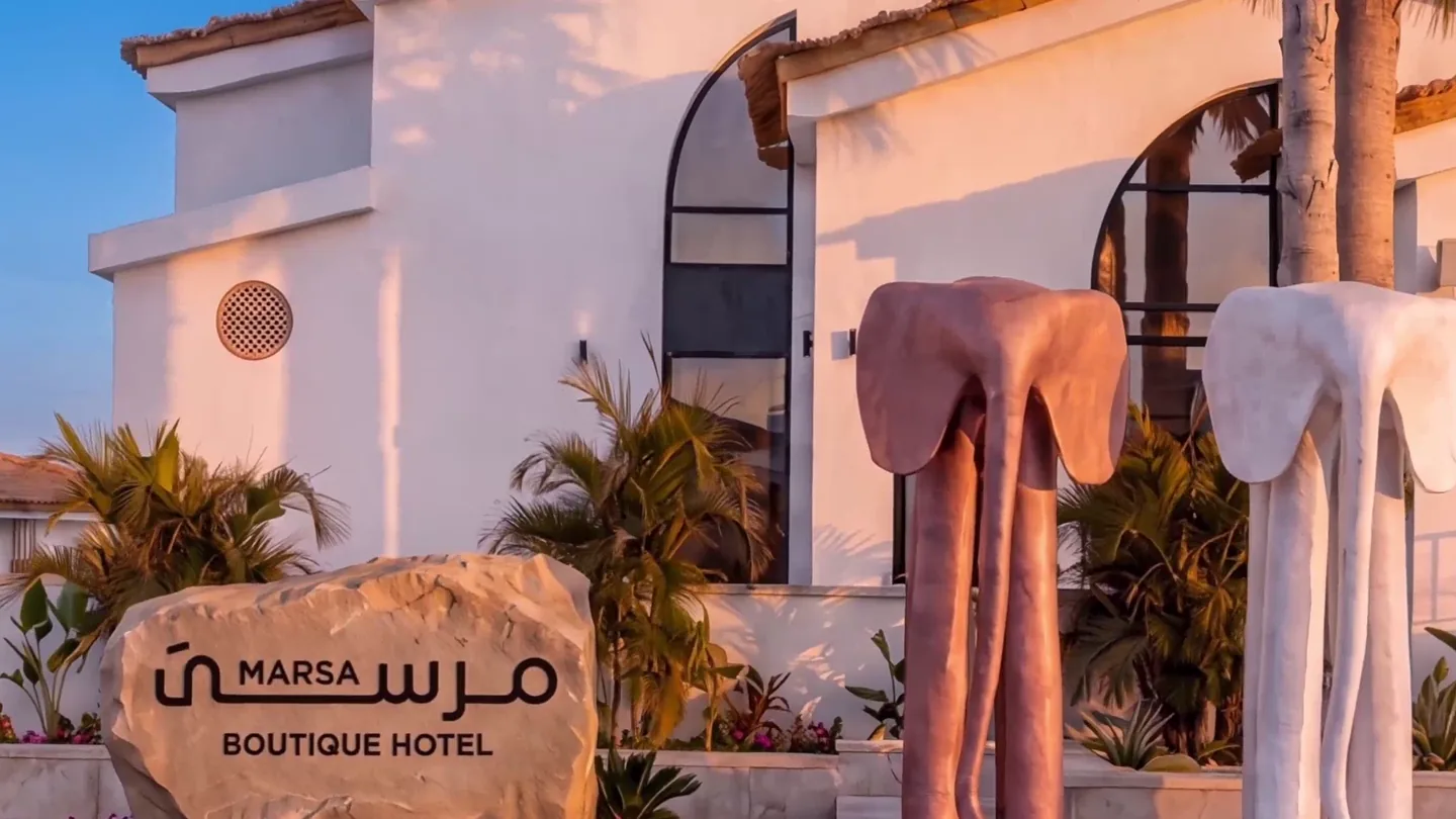 The arrival court at Marsa, with the carved stone sign and the two sculptures beside the entrance